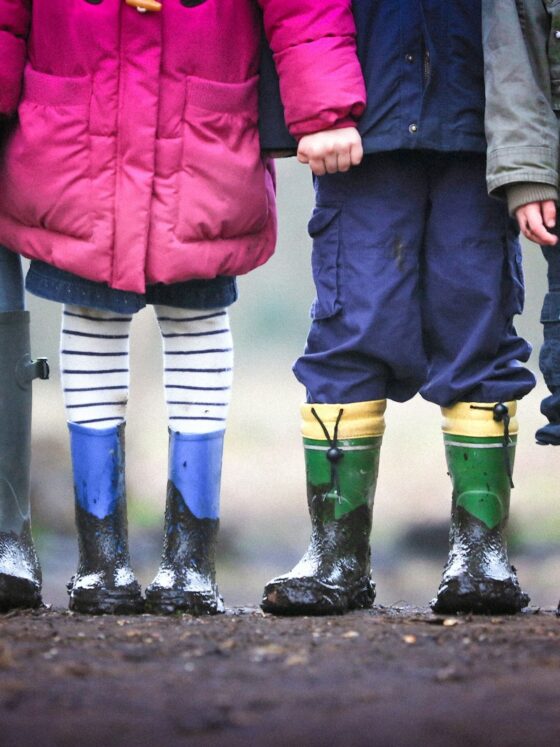 four children standing on dirt during daytime